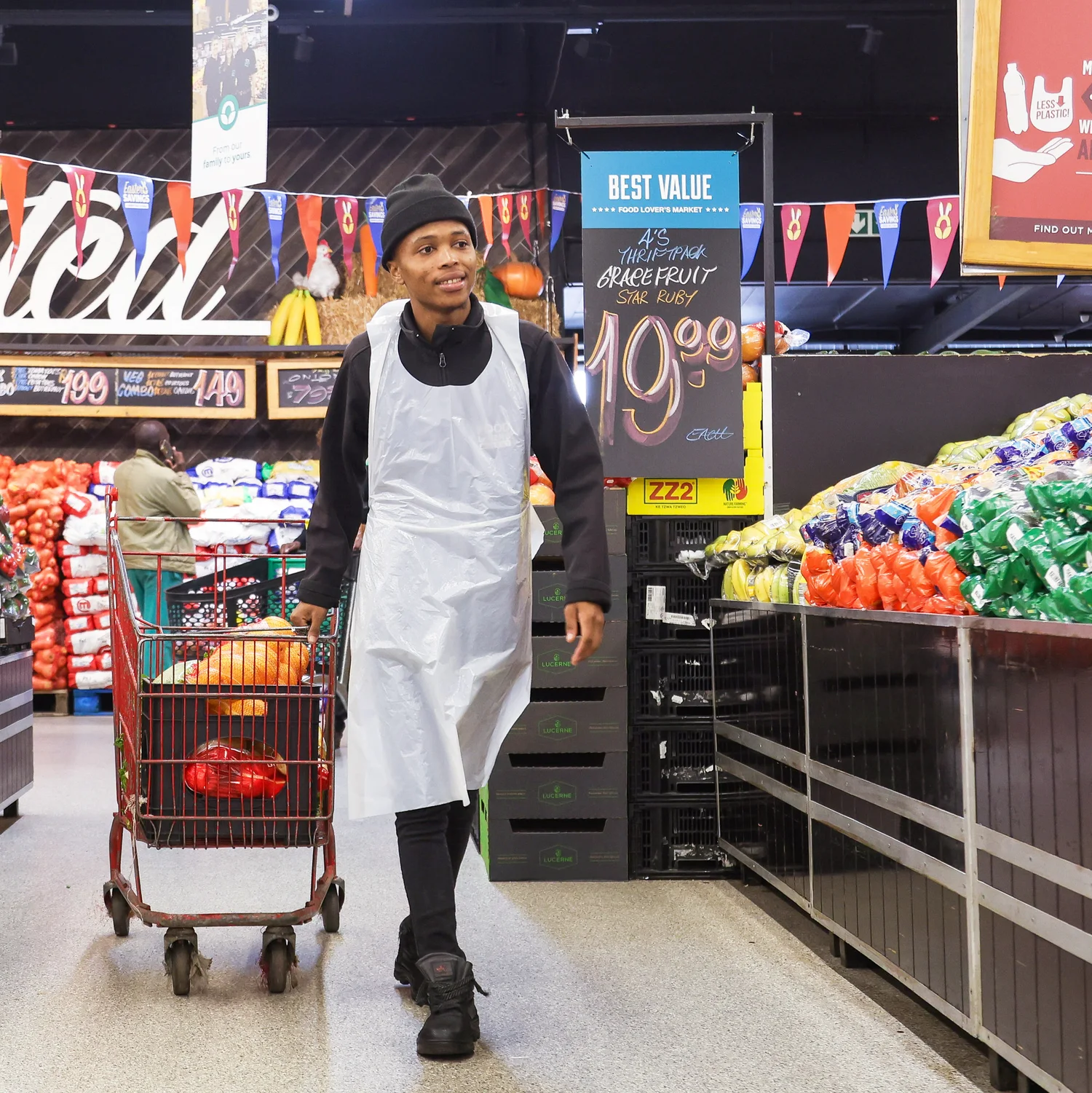 Njabulo pushes a grocery cart through the aisle a national retail store.